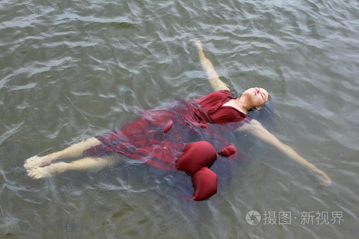 年轻美女穿红裙子躺在室外水淹死照片-正版商用图片0s