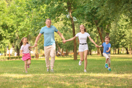 快乐的家庭一起走在绿色公园