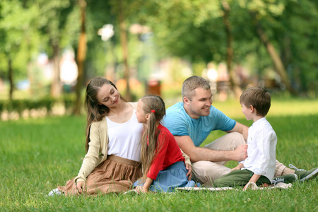 快乐的家庭休息在格子在公园