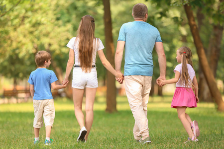 快乐的家庭一起走在绿色公园