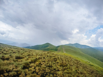 乌克兰夏季绿色的山脉。天空越过群山。乘吉普车旅行时的大气景观。越野远征