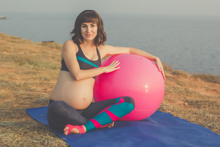 怀孕的女孩与粉红色 fitball
