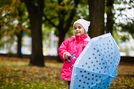 秋天公园小女孩用雨伞散步