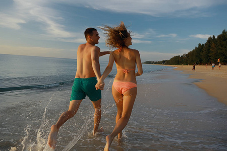 愉快的情侣沿着海滩奔跑, 健康休息, 运动活动, 暑假