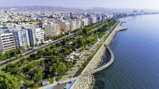 位于塞浦路斯利马索尔市中心海岸的 Molos 海滨公园鸟瞰图。鸟瞰的码头, 海滨步行路径, 棕榈树, 地中海, 码头, 岩石, 