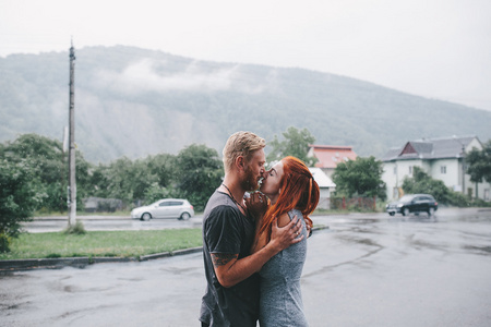 美丽的夫妇在雨中拥抱