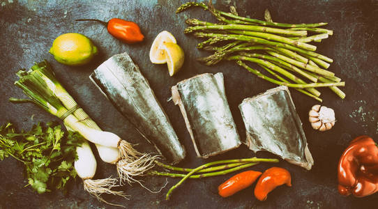 食品背景与生 sawfish 芦笋, 柠檬和草药。顶部视图。色调