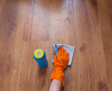 用蓝色抹布擦木地板的女人手图片