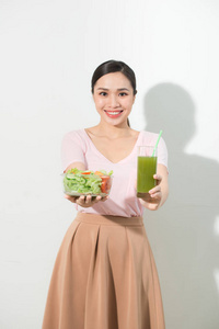 妇女与绿色排毒果汁, 沙拉在玻璃碗中孤立的白色背景。适当的营养, 素食, 健康的生活方式, 节食的概念。要复制空间的区域