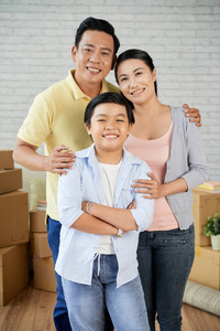 可爱的亚洲家庭在新的公寓与箱子