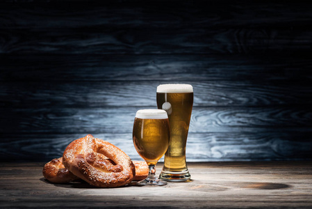 两杯美味的啤酒和美味的椒盐脆饼在木桌上, 啤酒节概念