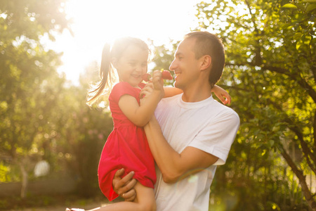 幸福微笑的年轻父亲和女儿在公园玩耍