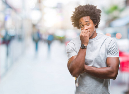 非裔美国人在孤立的背景下, 看着压力和紧张的嘴咬指甲的手。焦虑问题