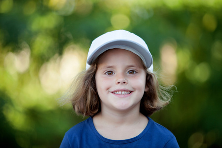 可爱的小女孩在公园里戴帽