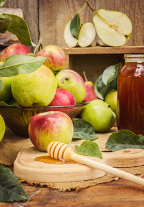 多汁，成熟的苹果和梨加蜂蜜木制背景