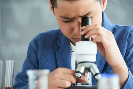 亚洲学生在学校实验室看显微镜