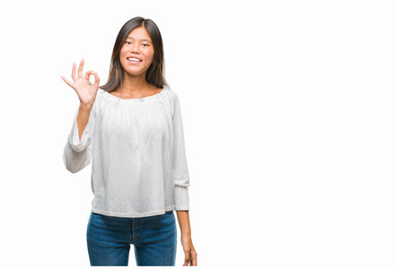 年轻的亚洲妇女在孤立的背景微笑积极做 ok 标志与手和手指。成功表达式