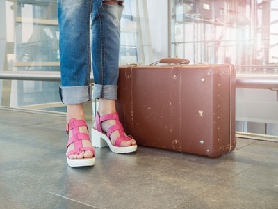 带的行李在机场大厅的年轻女人。在复古 st 的照片