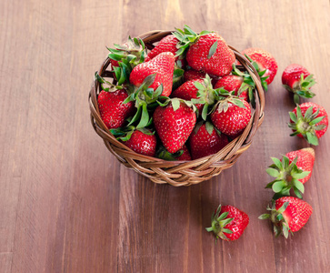 新鲜的草莓, 叶子放在篮子里。健康食品和饮食