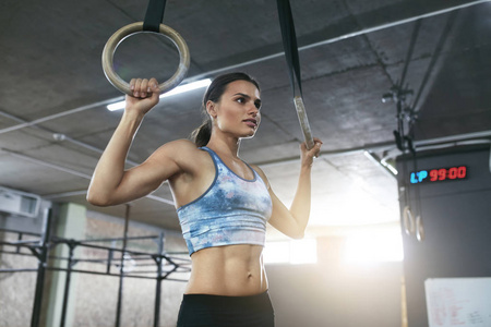 健身女子训练与体操戒指在 Crossfit 体育馆