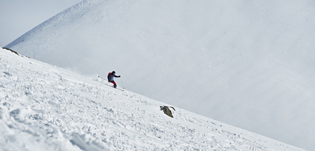 男子滑雪幻灯片在山腰