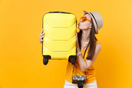 旅行者在夏季休闲服装, 帽子与手提箱孤立的黄色橙色背景。在周末外出旅行的女乘客。航空飞行旅途概念