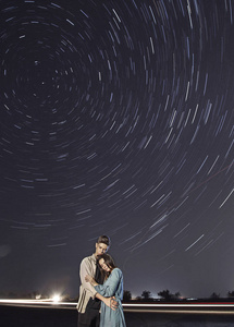 浪漫情侣在夜晚的星空下一对相爱的情侣在黑暗的背景下拥抱,夜晚,下雨