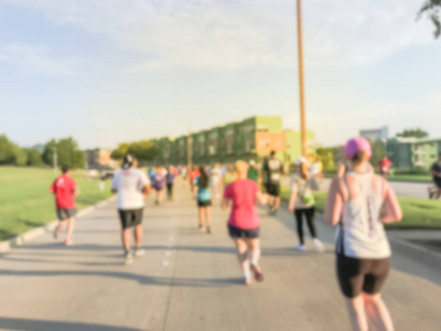 运动模糊群赛跑者的所有能力在5k 企业挑战赛在美国德克萨斯州理查森。健身和健康的生活方式概念。运动员在路上奔跑。城市体育活动文摘