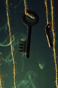 钥匙挂在一个字符串。烟的背景。选择性的焦点