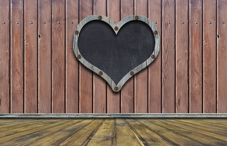 黑板心形在木墙上空黑板上, 木框为心形。挂在木墙上的木板