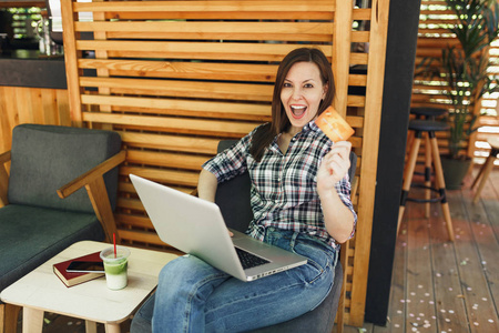 妇女在户外街道夏天咖啡馆咖啡馆坐在膝上型电脑电脑, 持有银行信用卡, 在空闲时间放松。移动办公室。生活方式自由职业者的商业概念