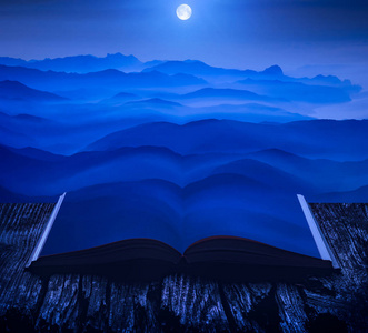 上升的满月以上的山谷上的页面上的一本开放的魔法书。雄伟的风景。自然与教育理念