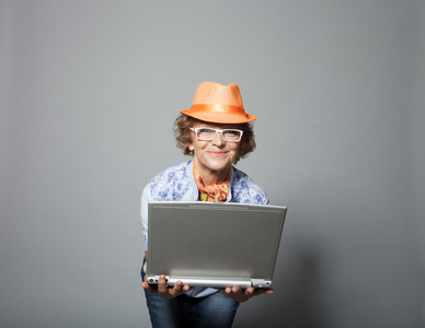 时尚的老女人带着便携式计算机