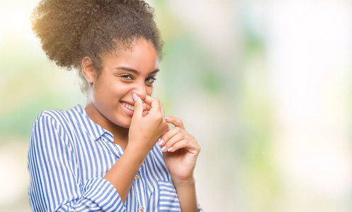 在与世隔绝的背景下, 年轻的美国黑人妇女闻到臭味和恶心, 无法忍受的气味, 用手指在鼻子上屏住呼吸。坏气味概念
