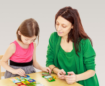 妈妈和女儿在桌子边玩益智游戏