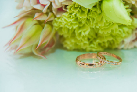 结婚戒指两个金戒指的新娘和新郎的钻石是在白色的表面