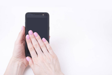 温柔的粉红色指甲。女性手用智能手机