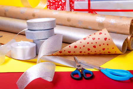 礼品包装，盒 纸 丝带和剪刀在彩色背景上。礼物的材料配件。关闭