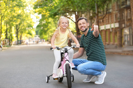 父亲教女儿骑自行车上街