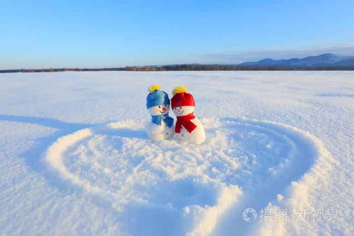 快乐的一对雪人在爱情中站在雪地上.画的心.文字2019.