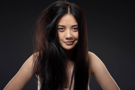 微笑亚洲妇女的肖像半打结和直发孤立在黑色, 角蛋白头发治疗概念