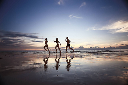 沿着海滩奔跑的运动员剪影, 暑假
