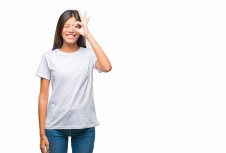 独立背景的年轻亚洲妇女做 ok 手势用手微笑, 眼睛看通过手指与愉快的面孔