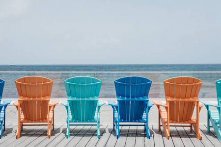彩色甲板椅的后景色排列在一排由海