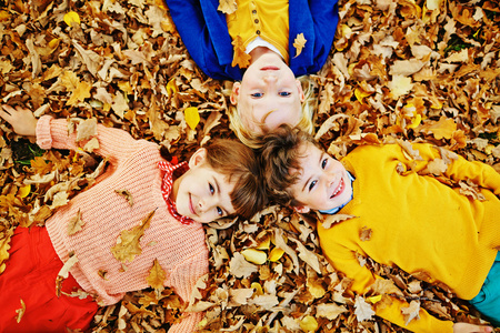 三个孩子躺在落叶