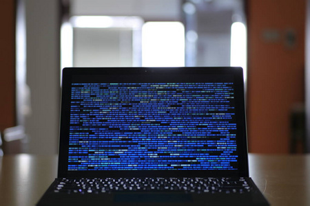 计算机开发人员和数据黑客。在显示器屏幕上使用二进制计算机代码的笔记本电脑。互联网隐私与网络安全