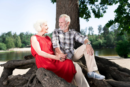 穿着米色长裤和运动鞋坐在妻子附近的大胡子的老人