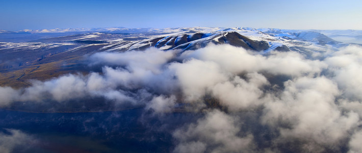 西伯利亚山地景观与雪和云所涵盖的山峰