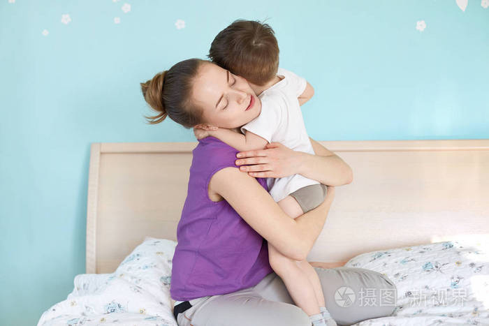 深情年轻的欧洲妈妈拥抱她的小男孩 享受平静的国内气氛 坐在舒适的