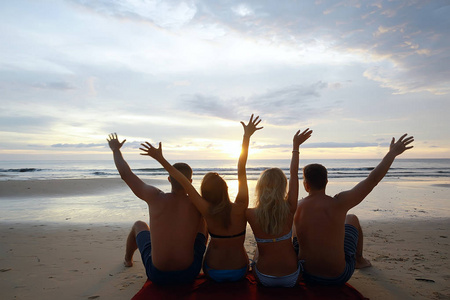 一群朋友在沙滩上晒日光浴, 快乐的人在海边放松身心